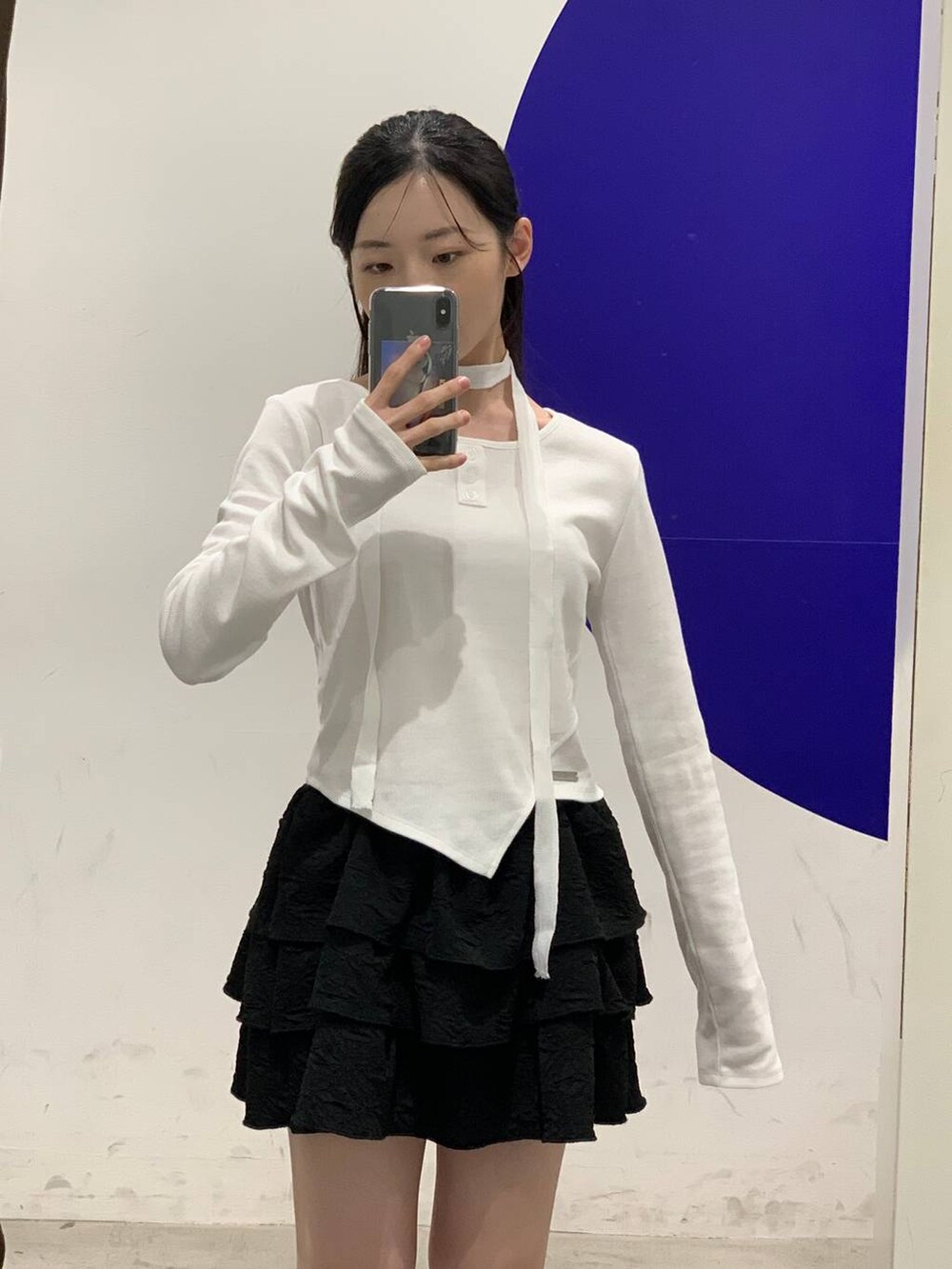 ブラック系のスカート、ホワイト系のTシャツ/カットソーを着用したレディースの秋コーディネートの6枚目の写真