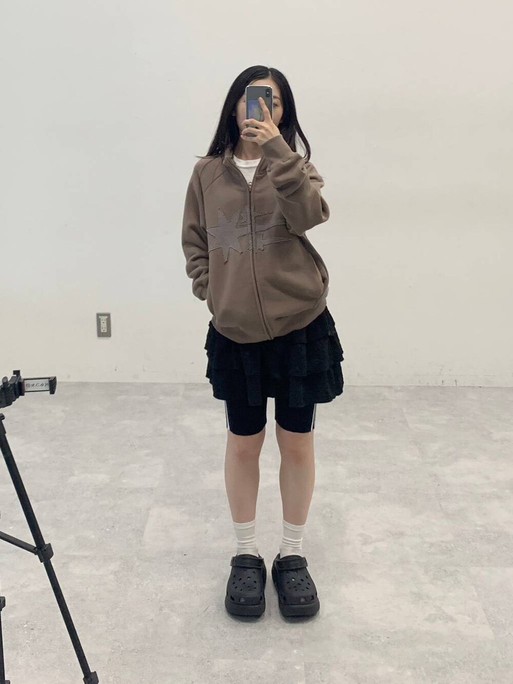 ブラック系のスカート、ベージュ系のパーカー、ブラック系のその他パンツを着用したレディースの秋コーディネートの2枚目の写真