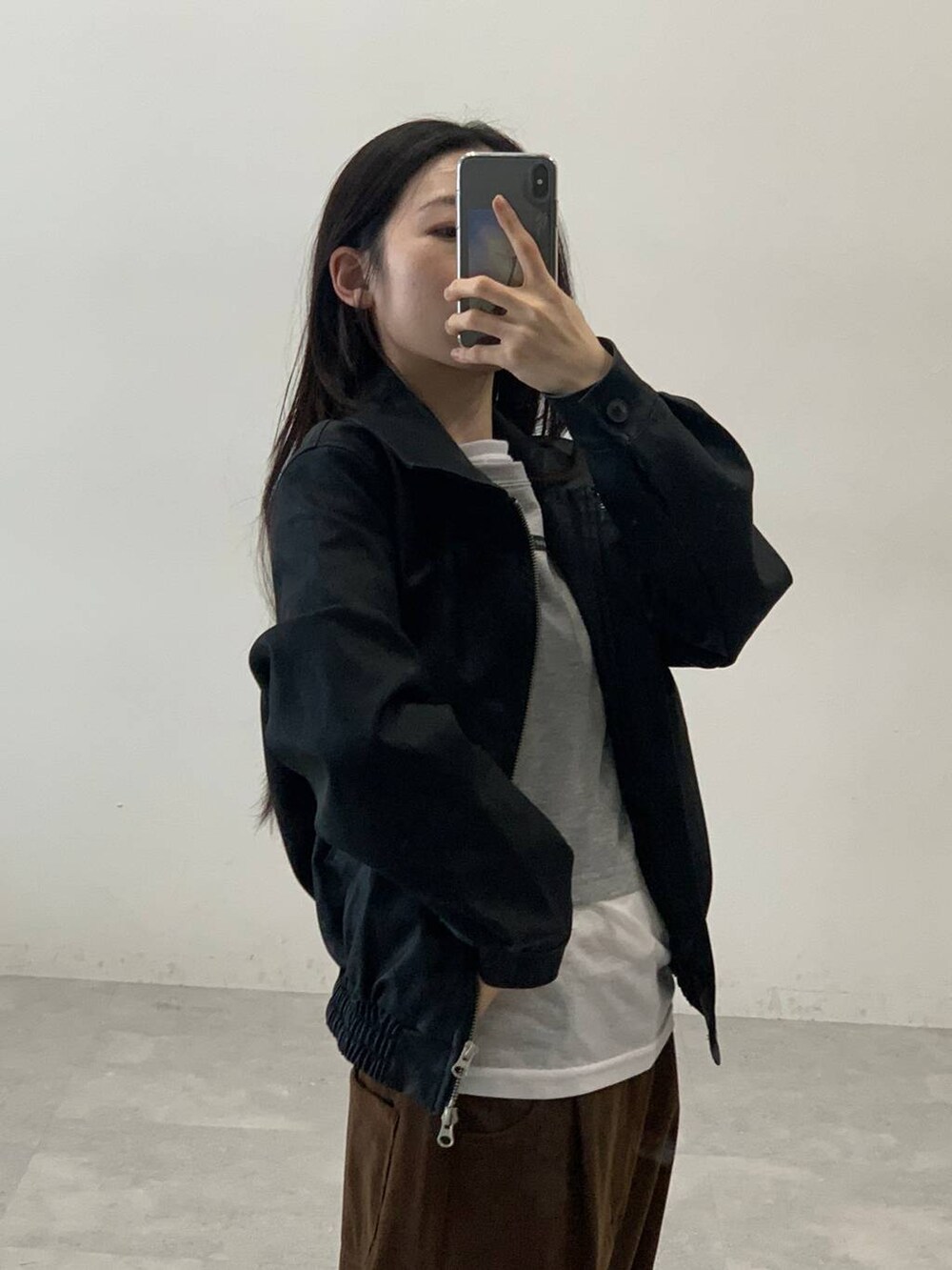 ホワイト系のTシャツ/カットソー、ブラック系のライダースジャケット、ブラウン系のその他パンツを着用したレディースの秋コーディネートの6枚目の写真
