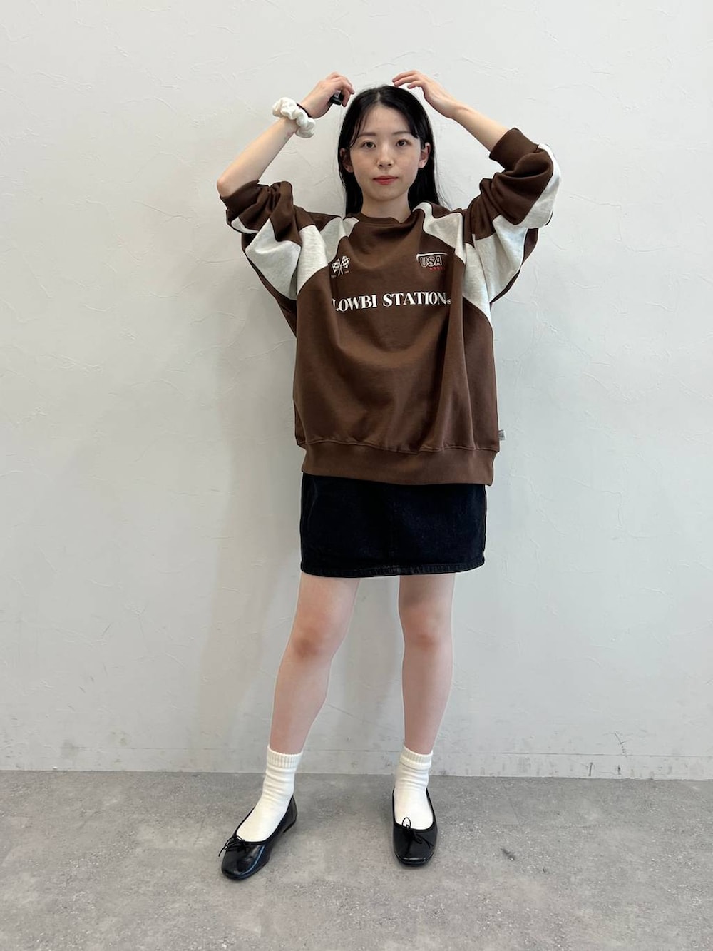 ブラック系のデニムスカート、ブラック系のバレエシューズ、ブラウン系のスウェットを着用したレディースの冬コーディネートの4枚目の写真