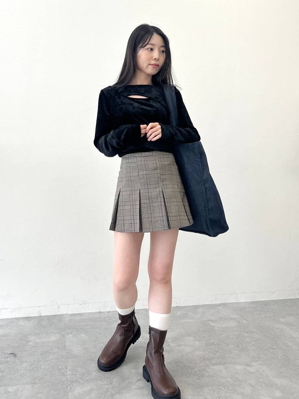 ブラック系のTシャツ/カットソー、ブラウン系のスカート、ブルー系のトートバッグを着用したレディースの冬コーディネートの4枚目の写真