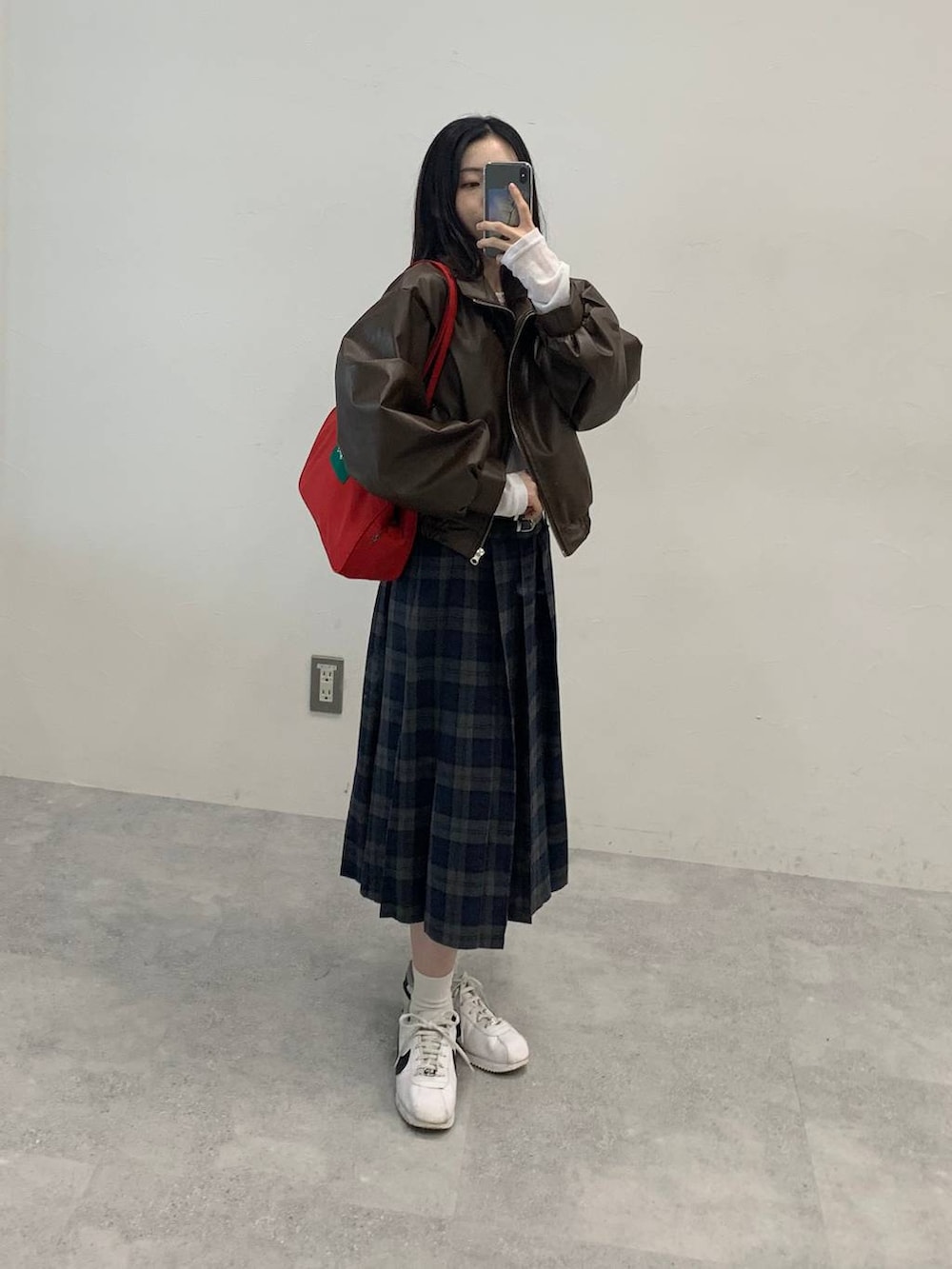 ブラック系のショルダーバッグ、ブラウン系のブルゾン、グレー系のスカートを着用したレディースの秋コーディネートの8枚目の写真