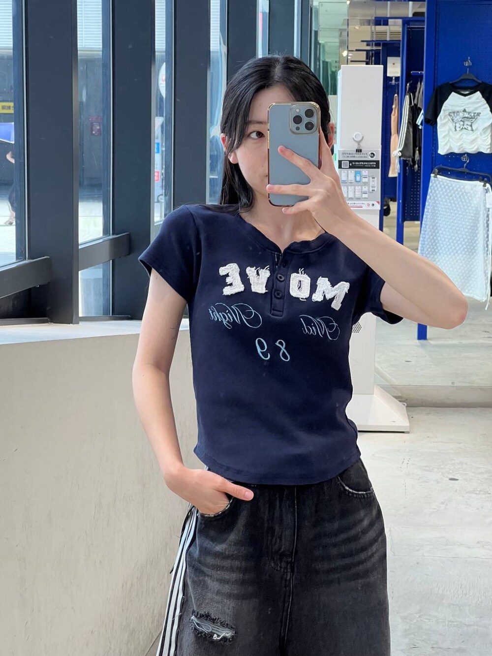 ブラック系のデニムパンツ、ブルー系のTシャツ/カットソー、ブラック系のベルトを着用したレディースの夏コーディネートの5枚目の写真