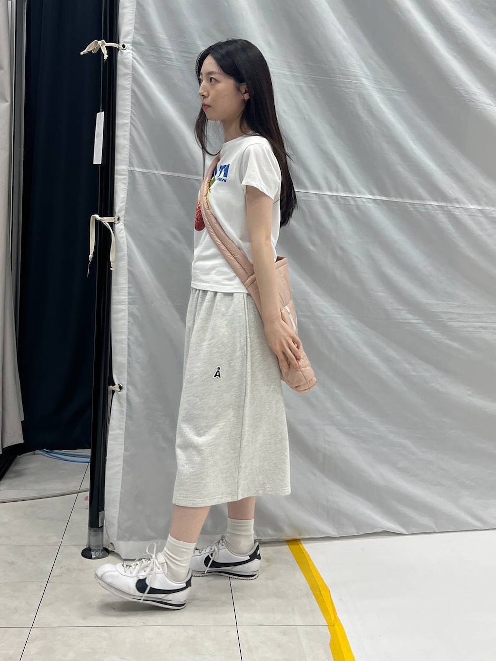 グレー系のスウェットパンツ、ピンク系のショルダーバッグ、ホワイト系のTシャツ/カットソーを着用したレディースの夏コーディネートの2枚目の写真