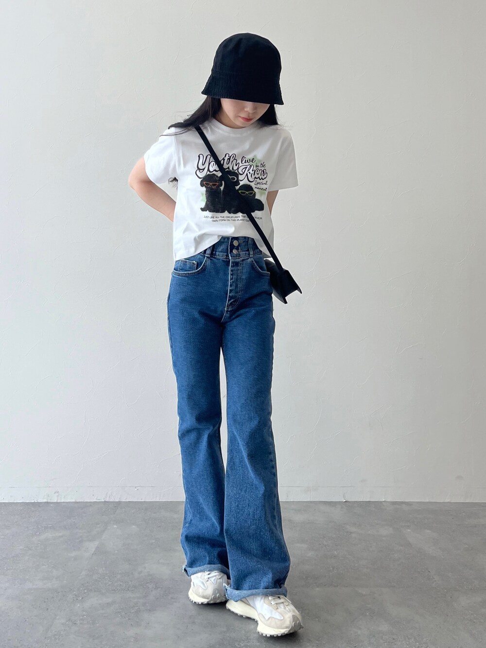 ホワイト系のTシャツ/カットソー、ブルー系のデニムパンツ、ホワイト系のスニーカーを着用したレディースの夏コーディネートの2枚目の写真