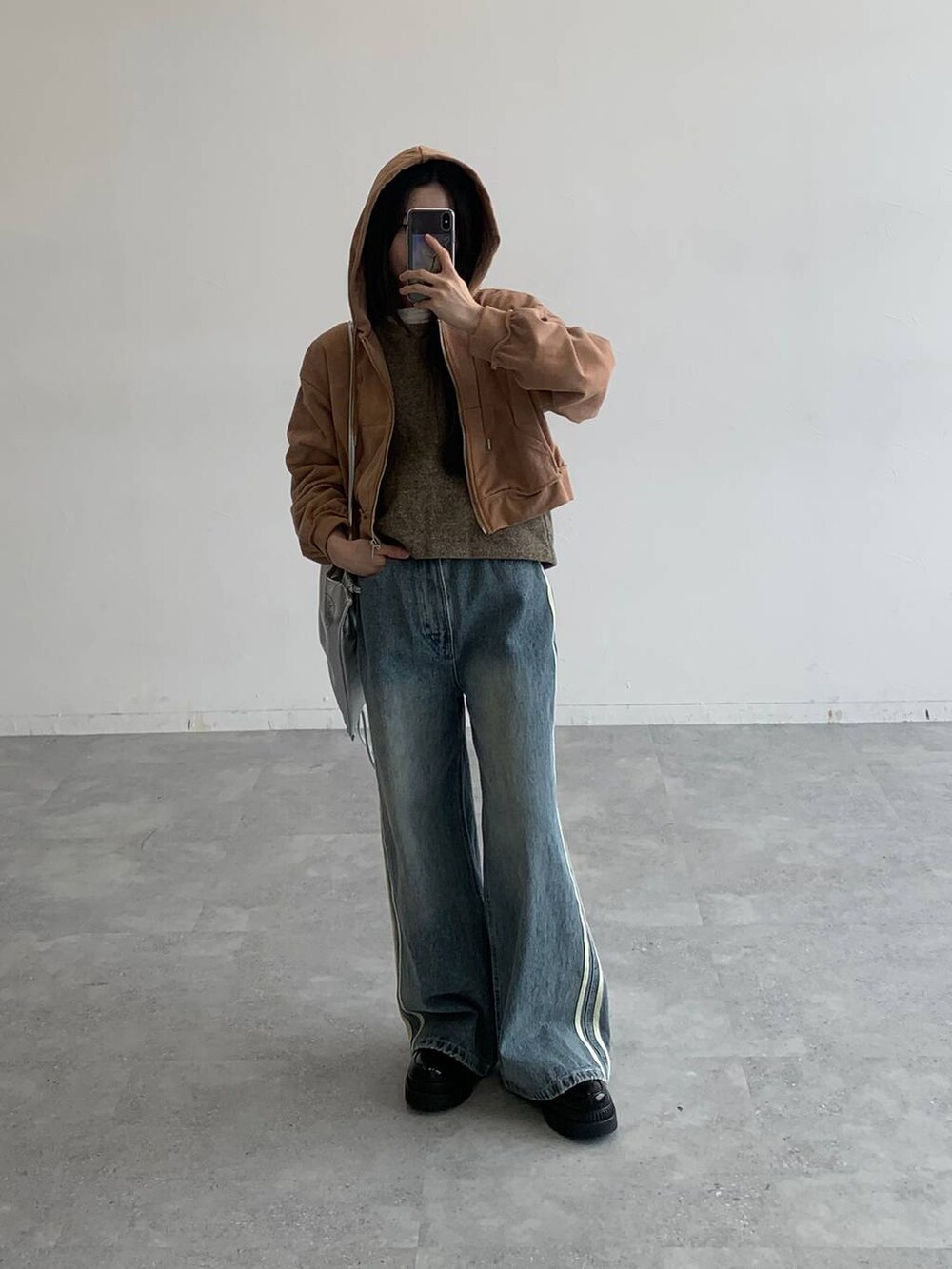 ブラウン系のパーカー、その他のデニムパンツ、グレー系のバックパック/リュックを着用したレディースの秋コーディネートの2枚目の写真