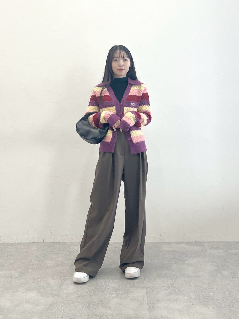 パープル系のカーディガン/ボレロ、ブラック系のTシャツ/カットソー、ブラウン系のスラックスを着用したレディースの冬コーディネートの4枚目の写真