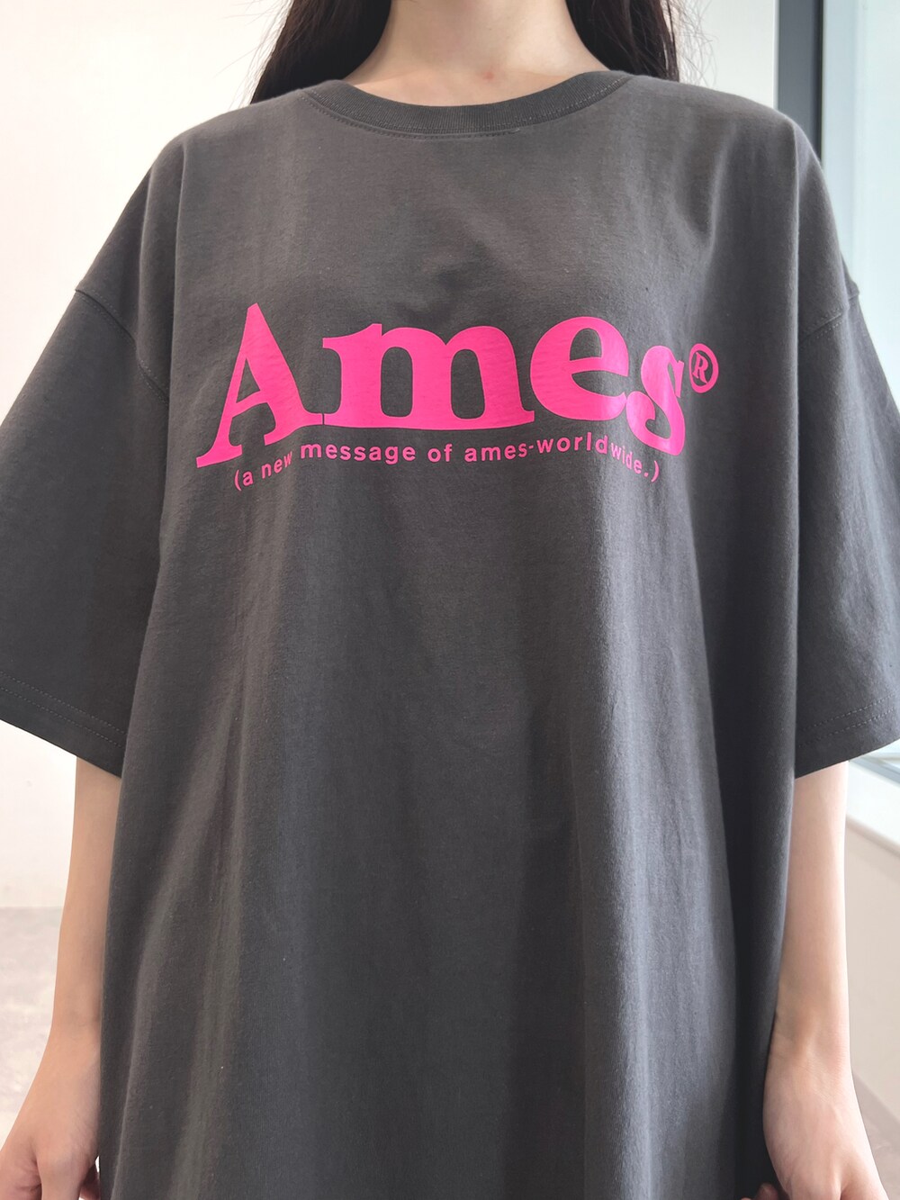 グレー系のTシャツ/カットソー、ブラック系のスカート、ホワイト系のスニーカーを着用したレディースの夏コーディネートの3枚目の写真