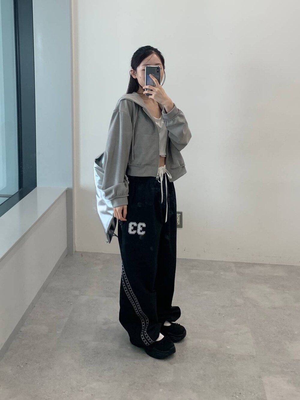 グレー系のパーカー、グレー系のバックパック/リュック、ブラック系のその他パンツを着用したレディースの秋コーディネートの3枚目の写真