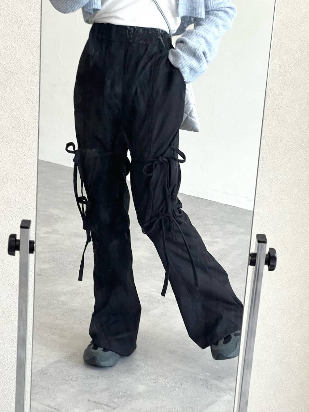 グレー系のショルダーバッグ、ベージュ系のTシャツ/カットソー、ブラック系のスラックスを着用したレディースの冬コーディネートの5枚目の写真