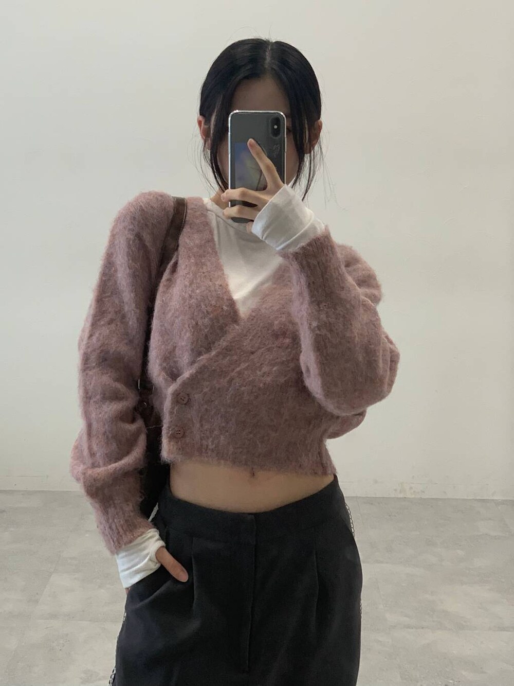 オレンジ系のカーディガン/ボレロ、グレー系のスラックス、ベージュ系のTシャツ/カットソーを着用したレディースの秋コーディネートの6枚目の写真