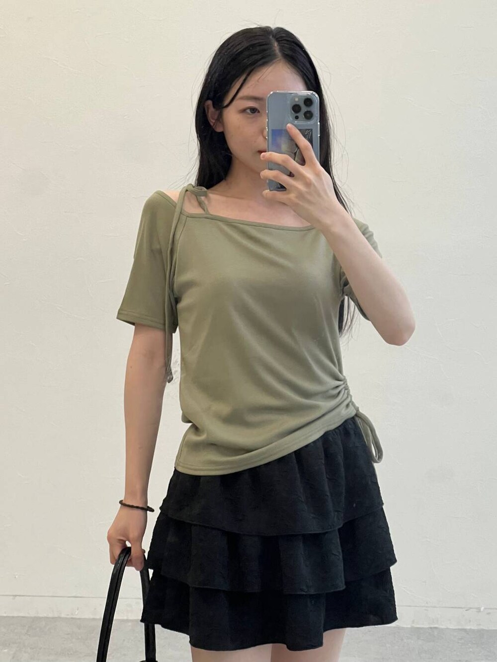 グリーン系のTシャツ/カットソー、ブラック系のハンドバッグ、ブラック系のスカートを着用したレディースの夏コーディネートの8枚目の写真