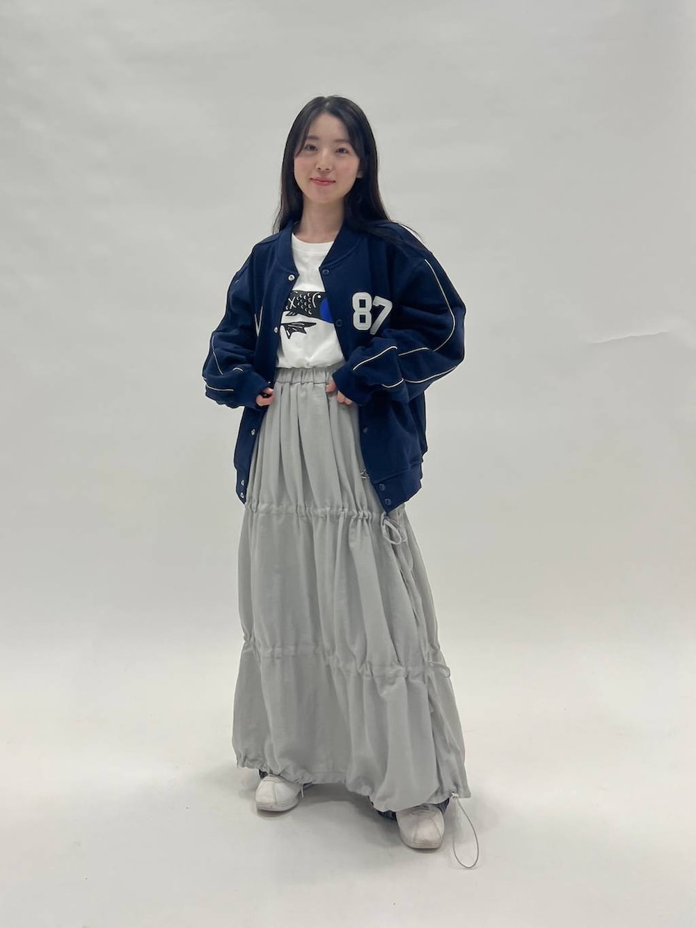 ホワイト系のTシャツ/カットソー、ブラック系のデニムパンツ、ブルー系のブルゾンを着用したレディースの冬コーディネートの2枚目の写真