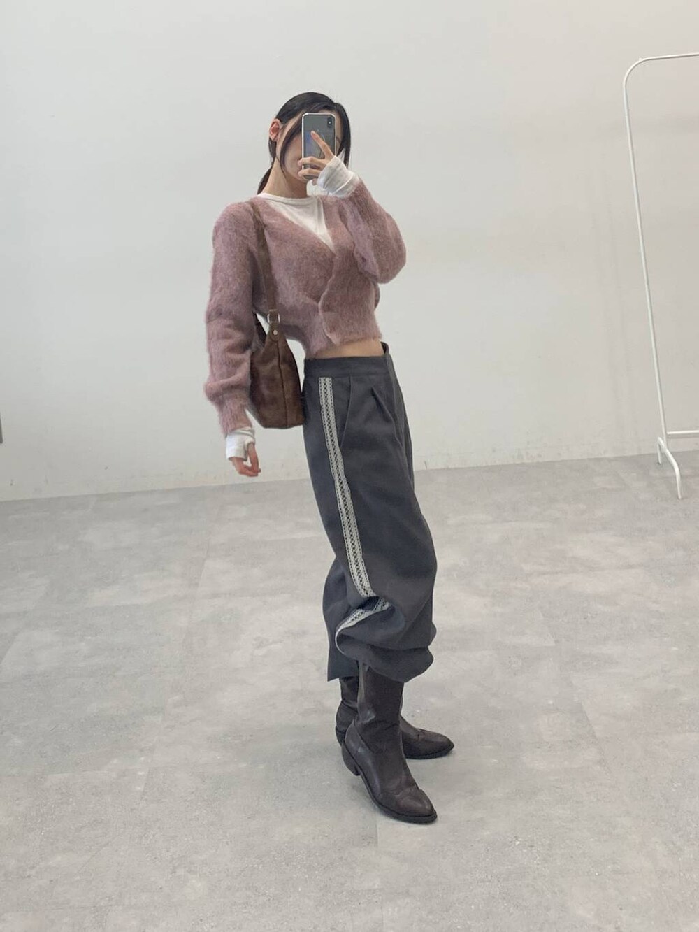 オレンジ系のカーディガン/ボレロ、グレー系のスラックス、ベージュ系のTシャツ/カットソーを着用したレディースの秋コーディネートの3枚目の写真