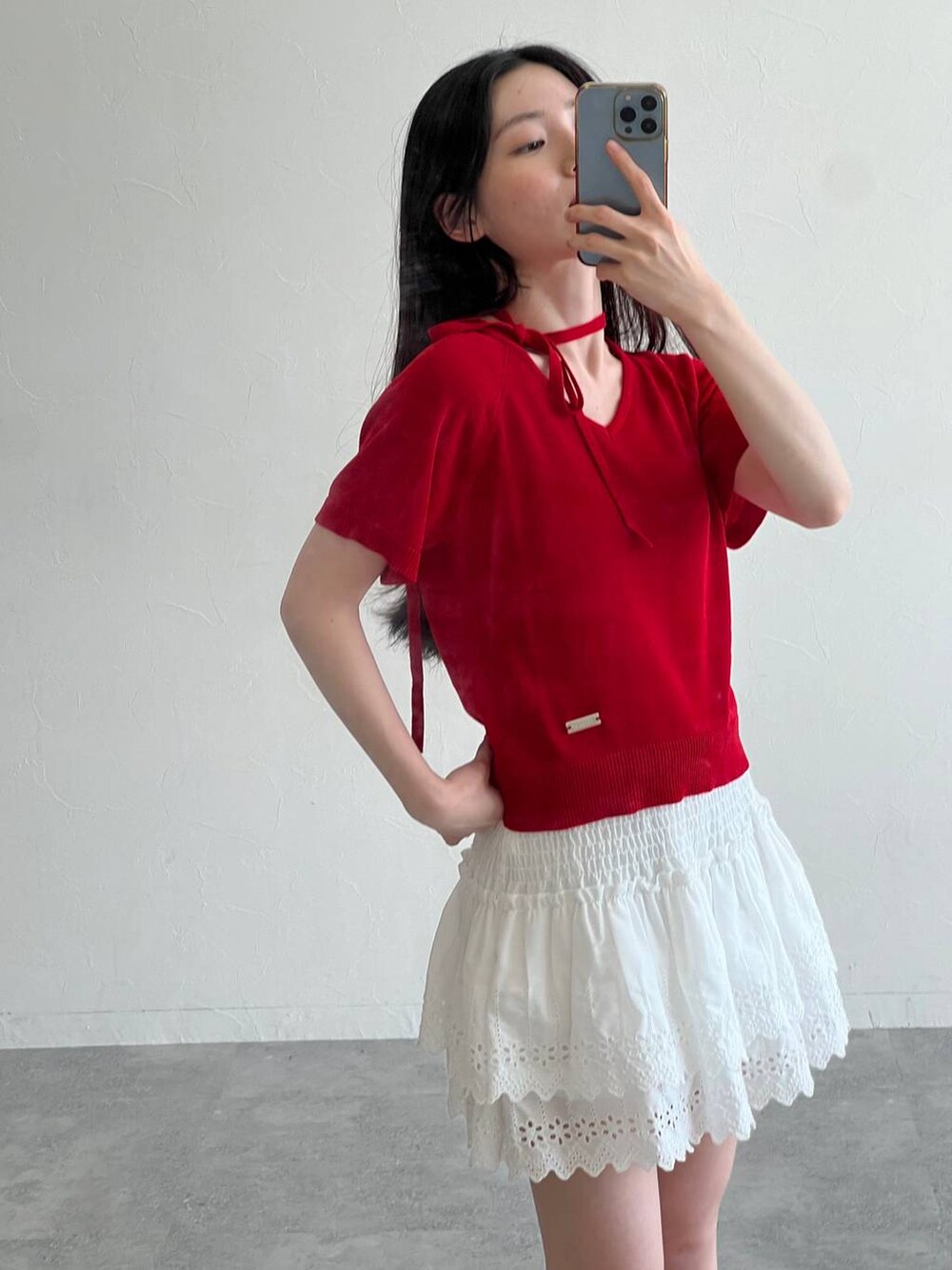 ホワイト系のスカート、ブラック系のトートバッグ、レッド系のニット/セーターを着用したレディースの夏コーディネートの3枚目の写真