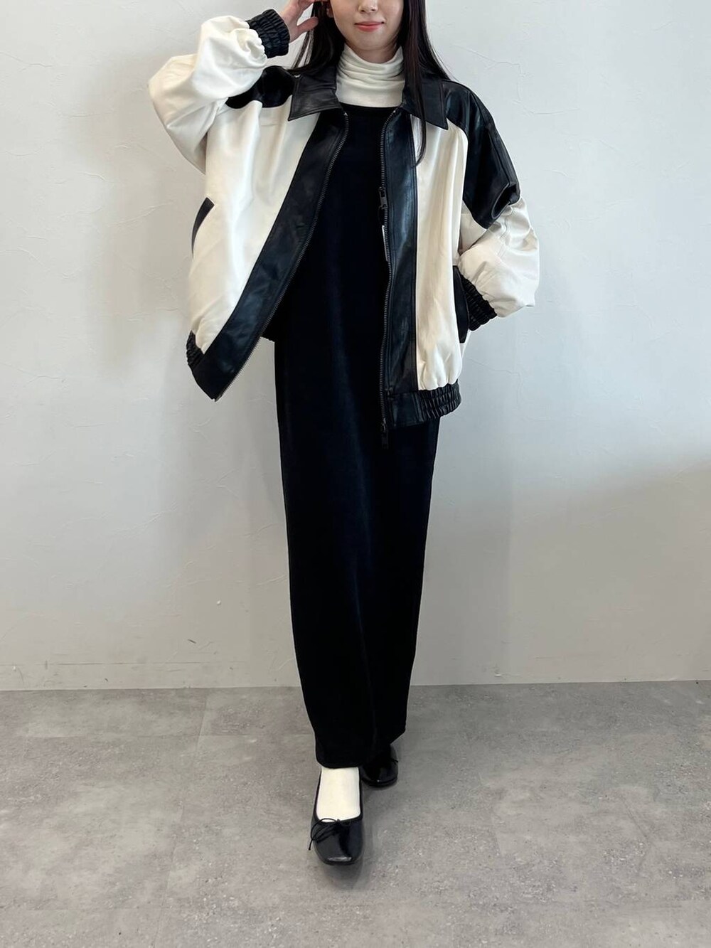 ブラック系のワンピース、ブラック系のバレエシューズ、ベージュ系のTシャツ/カットソーを着用したレディースの冬コーディネートの2枚目の写真