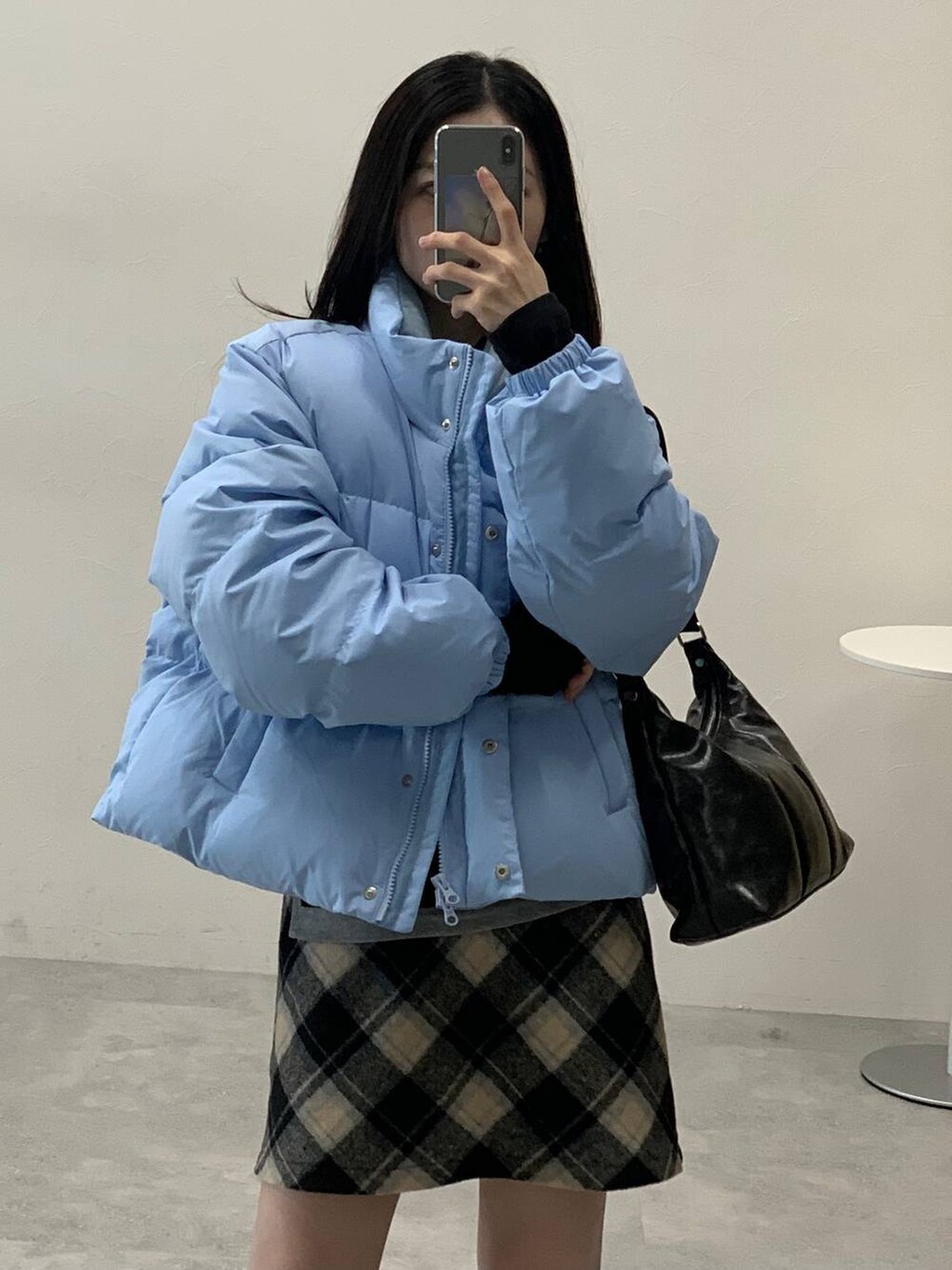 ブラック系のスカート、ブラック系のハンドバッグ、ブラック系のTシャツ/カットソーを着用したレディースの冬コーディネートの9枚目の写真