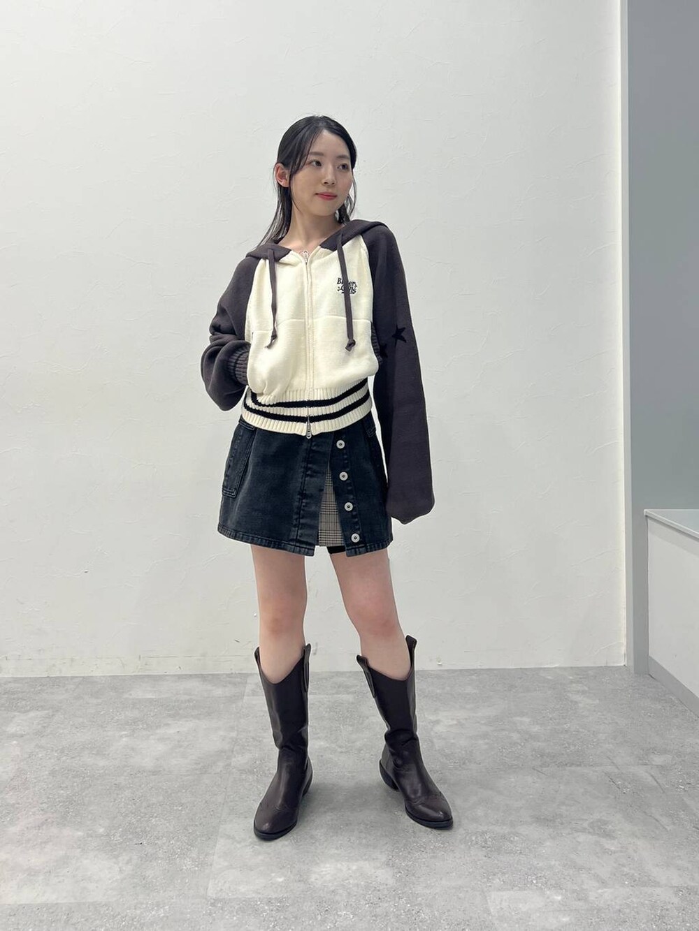 ブラウン系のスカート、ブラック系のデニムパンツを着用したレディースの春コーディネートの3枚目の写真