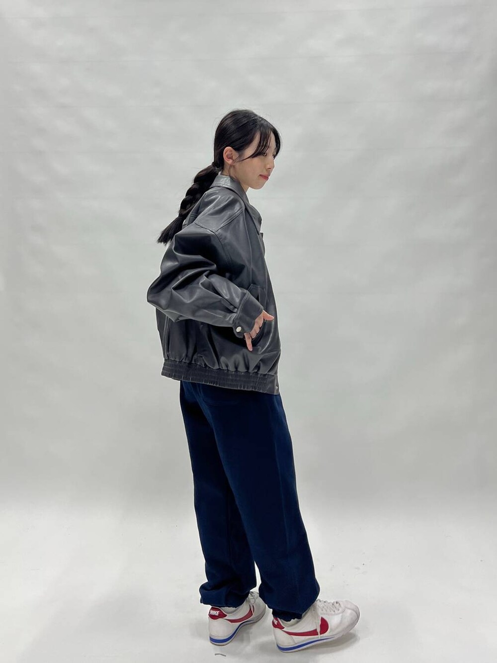 グレー系のブルゾン、ホワイト系のスニーカー、ブルー系のスウェットパンツを着用したレディースの冬コーディネートの3枚目の写真