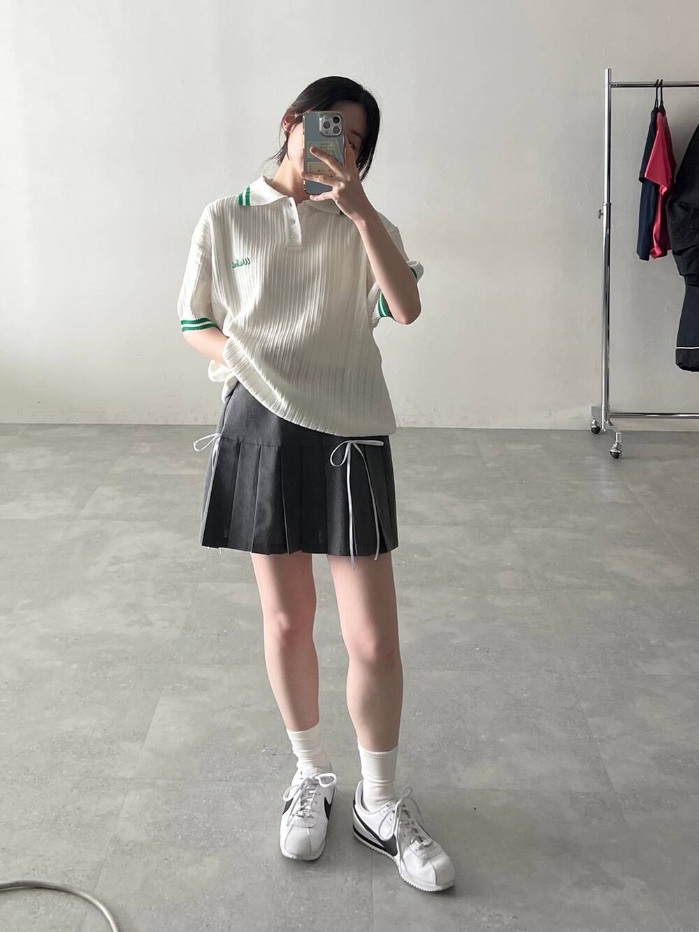 グレー系のスカート、ベージュ系のニット/セーターを着用したレディースの夏コーディネートの2枚目の写真