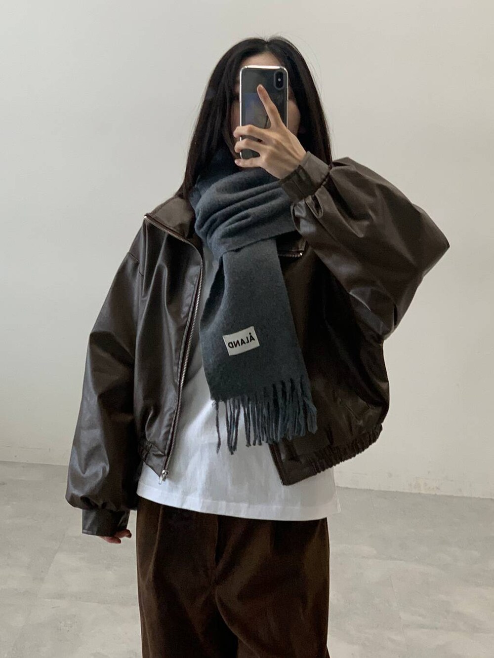 ブラウン系のブルゾン、ブラウン系のその他パンツ、グレー系のマフラーを着用したレディースの秋コーディネートの3枚目の写真