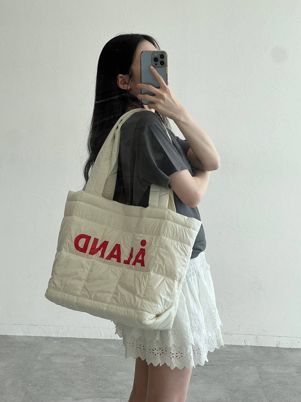 ホワイト系のスカート、ホワイト系のボストンバッグ、グレー系のTシャツ/カットソーを着用したレディースの夏コーディネートの6枚目の写真