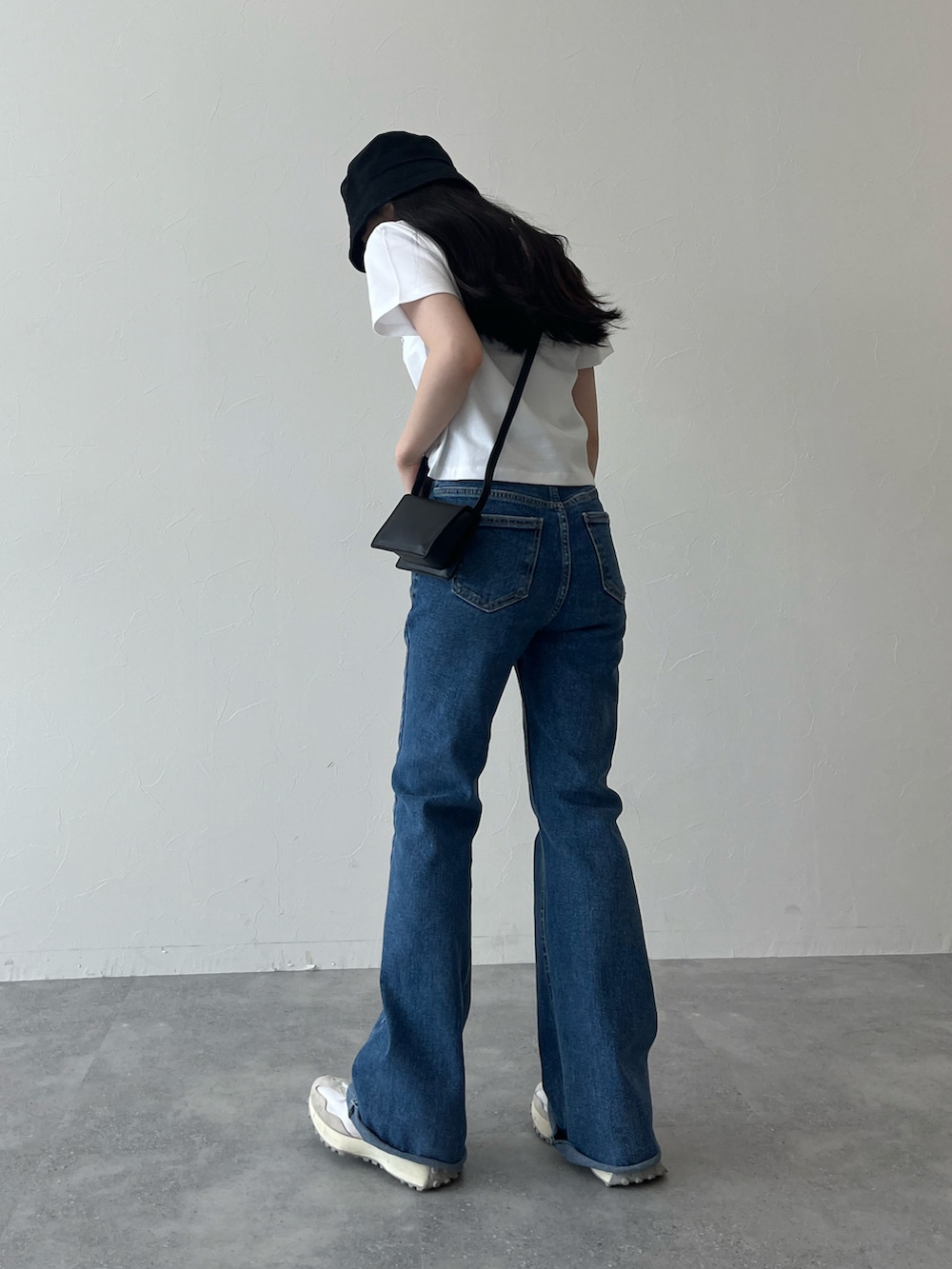 ホワイト系のTシャツ/カットソー、ブルー系のデニムパンツ、ホワイト系のスニーカーを着用したレディースの夏コーディネートの3枚目の写真