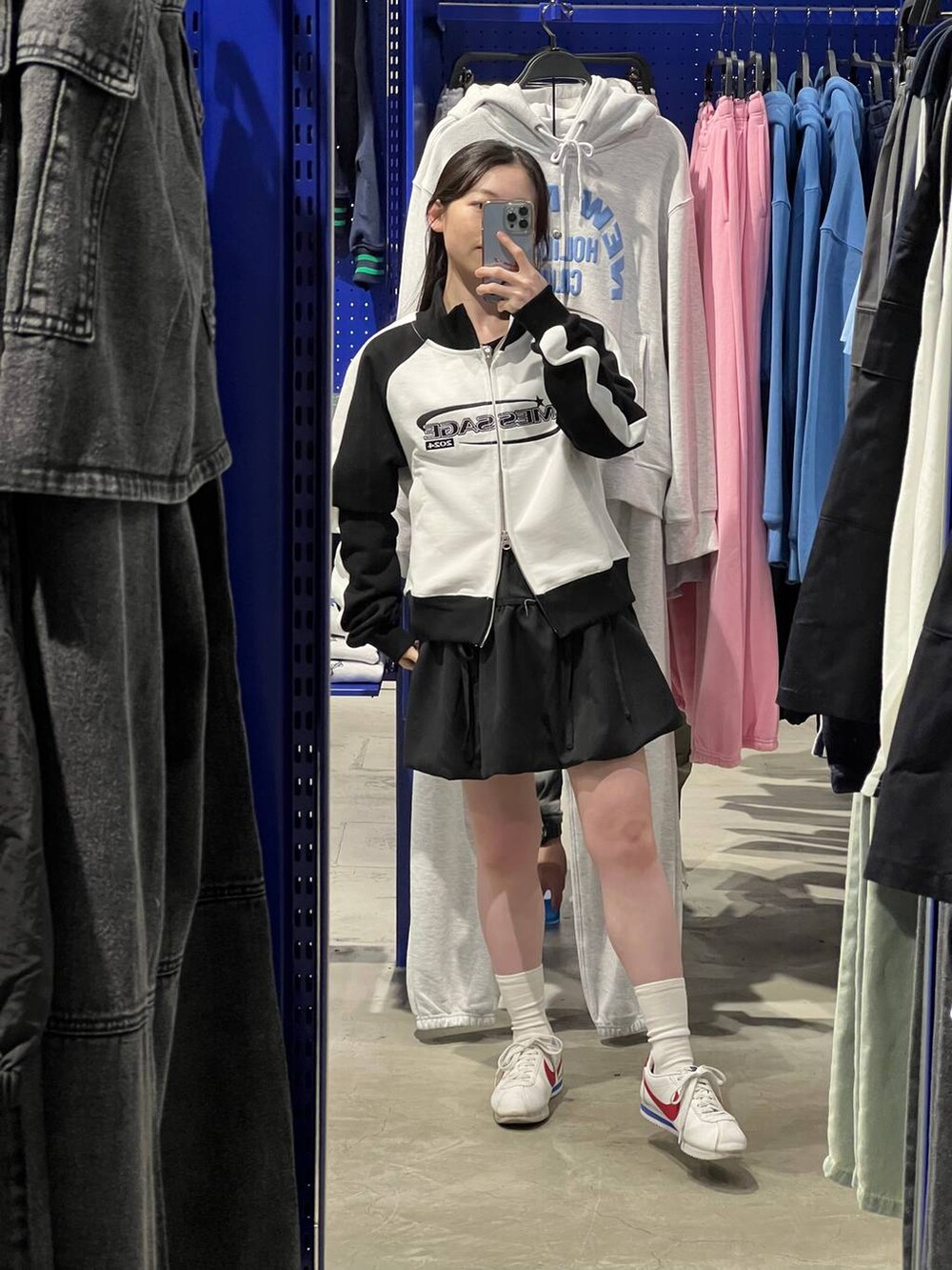 ブラック系のスカート、ホワイト系のスウェットを着用したレディースの春コーディネートの2枚目の写真