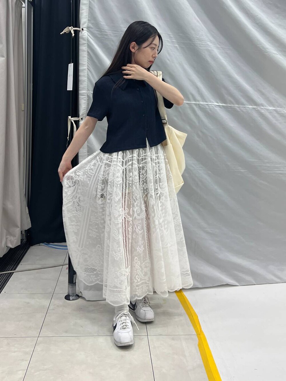 ホワイト系のスカート、ベージュ系のショルダーバッグ、グレー系のデニムパンツを着用したレディースの夏コーディネートの5枚目の写真