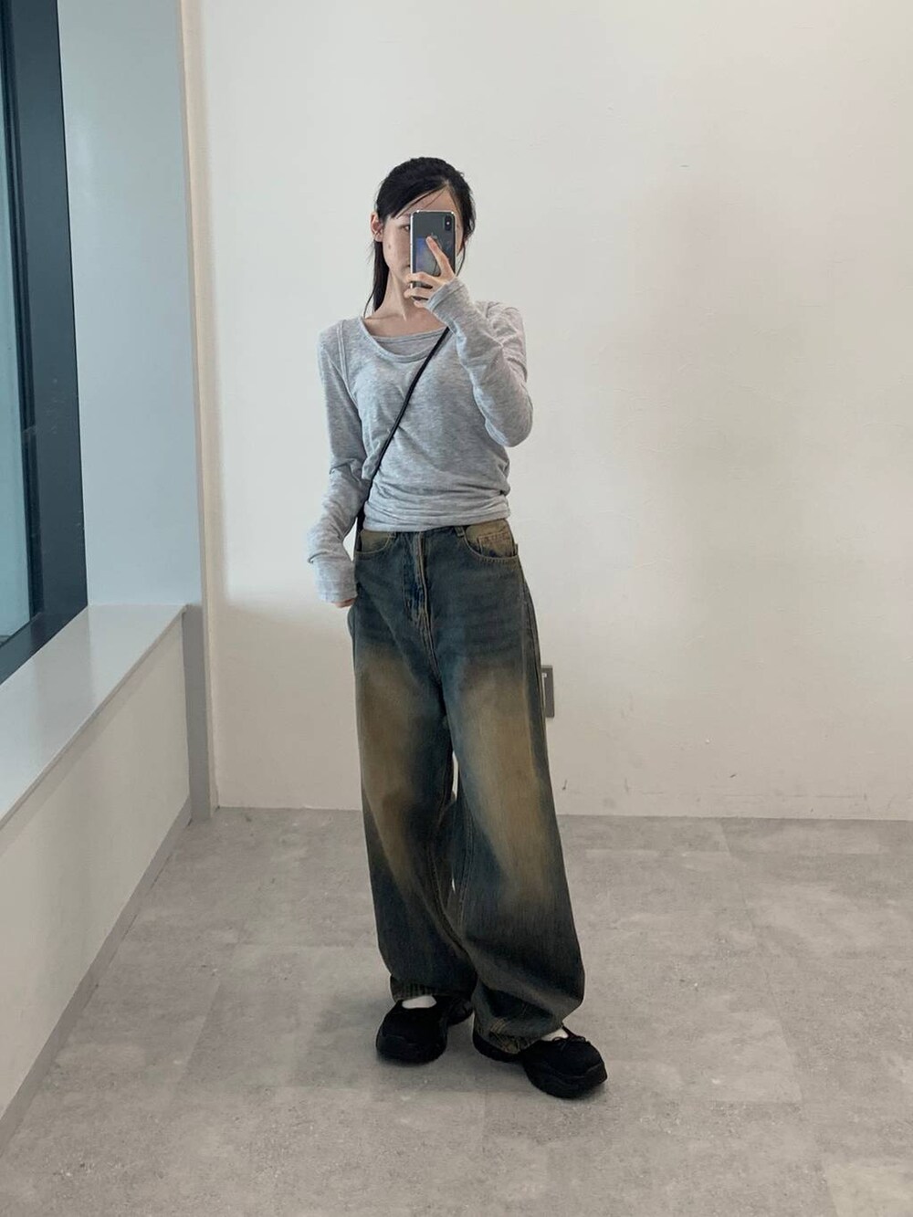 ブルー系のデニムパンツ、グレー系のTシャツ/カットソーを着用したレディースの秋コーディネートの4枚目の写真