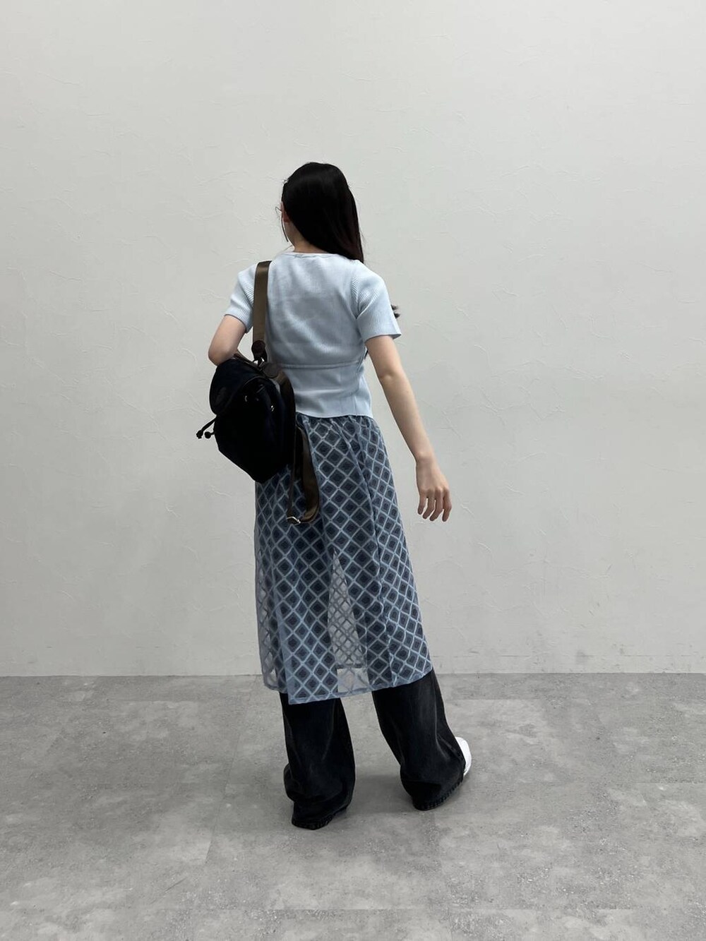 ブルー系のスカート、ブラック系のデニムパンツ、ブルー系のカーディガン/ボレロを着用したレディースの春コーディネートの4枚目の写真