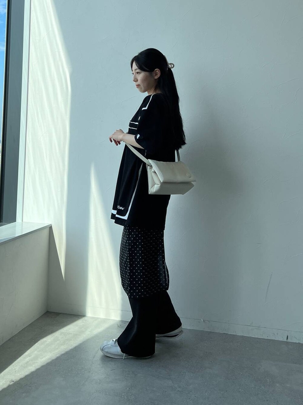 ホワイト系のハンドバッグ、ブラック系のスカートを着用したレディースの夏コーディネートの5枚目の写真