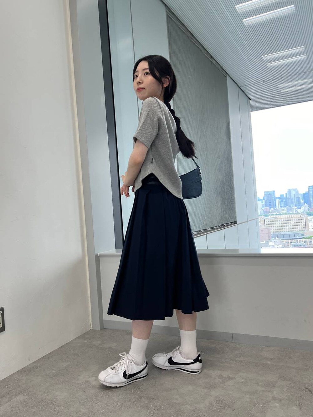 ブルー系のスカート、ブルー系のトートバッグ、グレー系のTシャツ/カットソーを着用したレディースの夏コーディネートの4枚目の写真