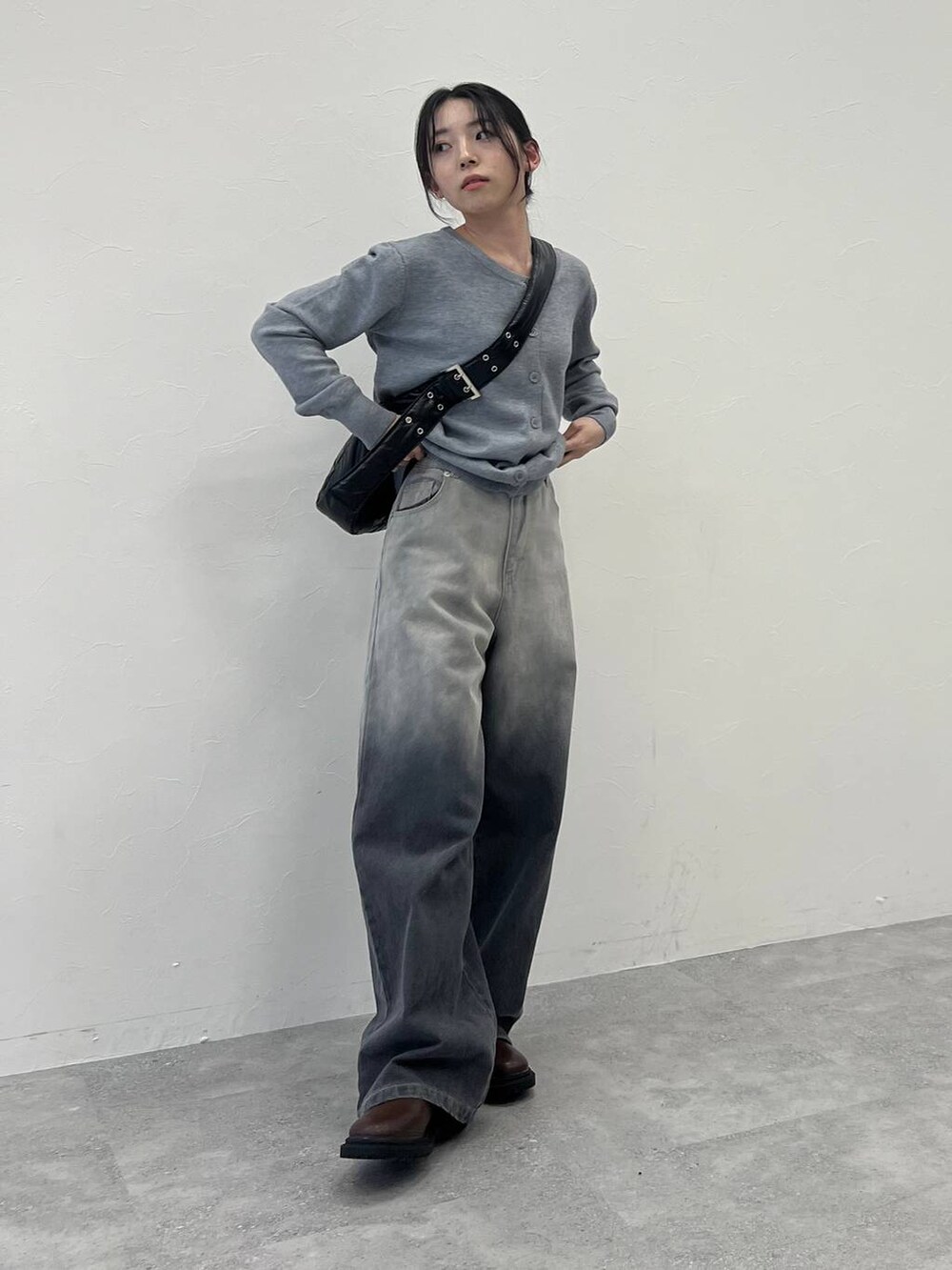 ブラック系のショルダーバッグ、ブラック系のデニムパンツ、グレー系のカーディガン/ボレロを着用したレディースの冬コーディネートの5枚目の写真