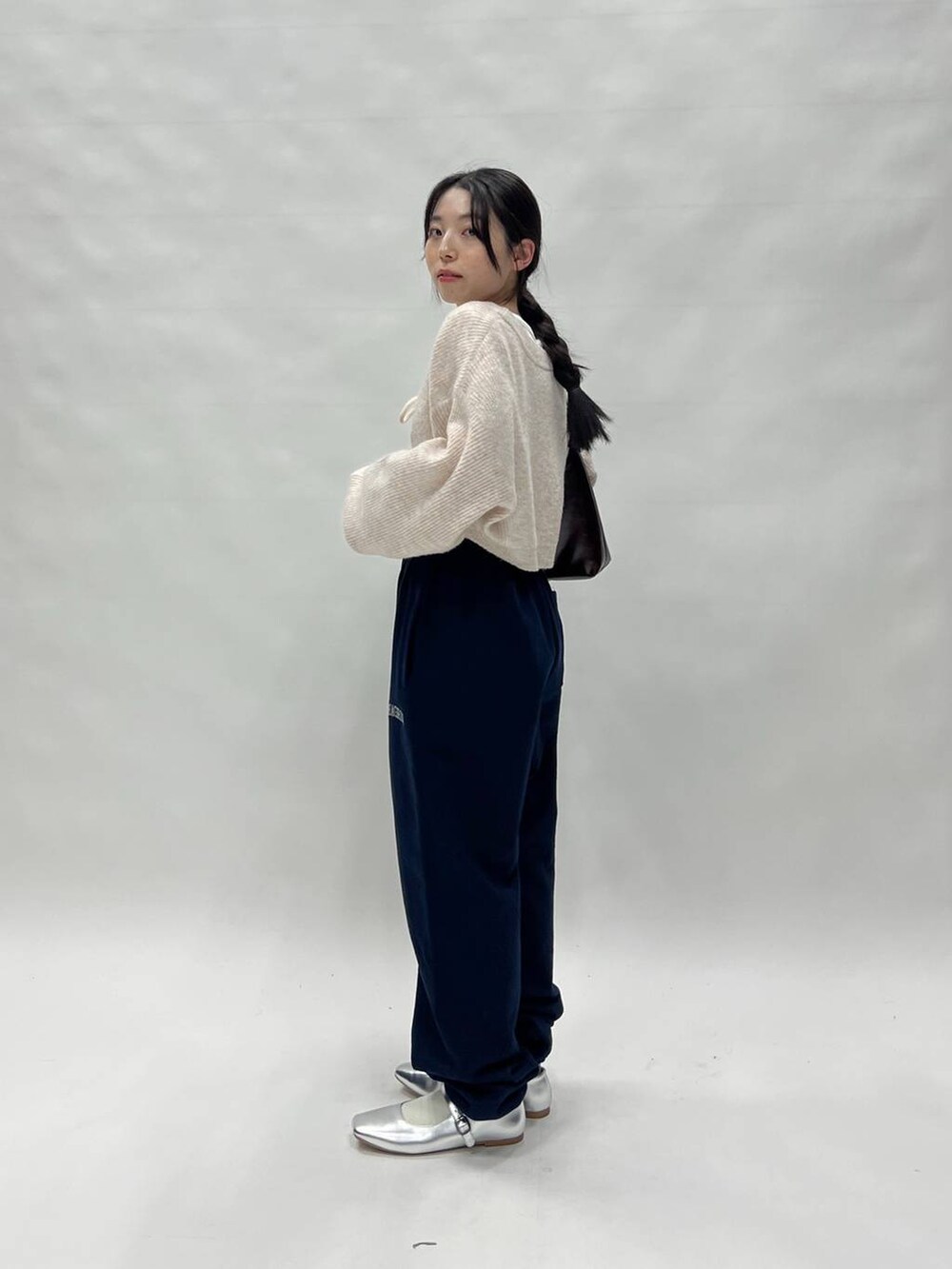 ブラック系のスウェットパンツ、ピンク系のカーディガン/ボレロ、ブラウン系のバッグを着用したレディースの冬コーディネートの4枚目の写真