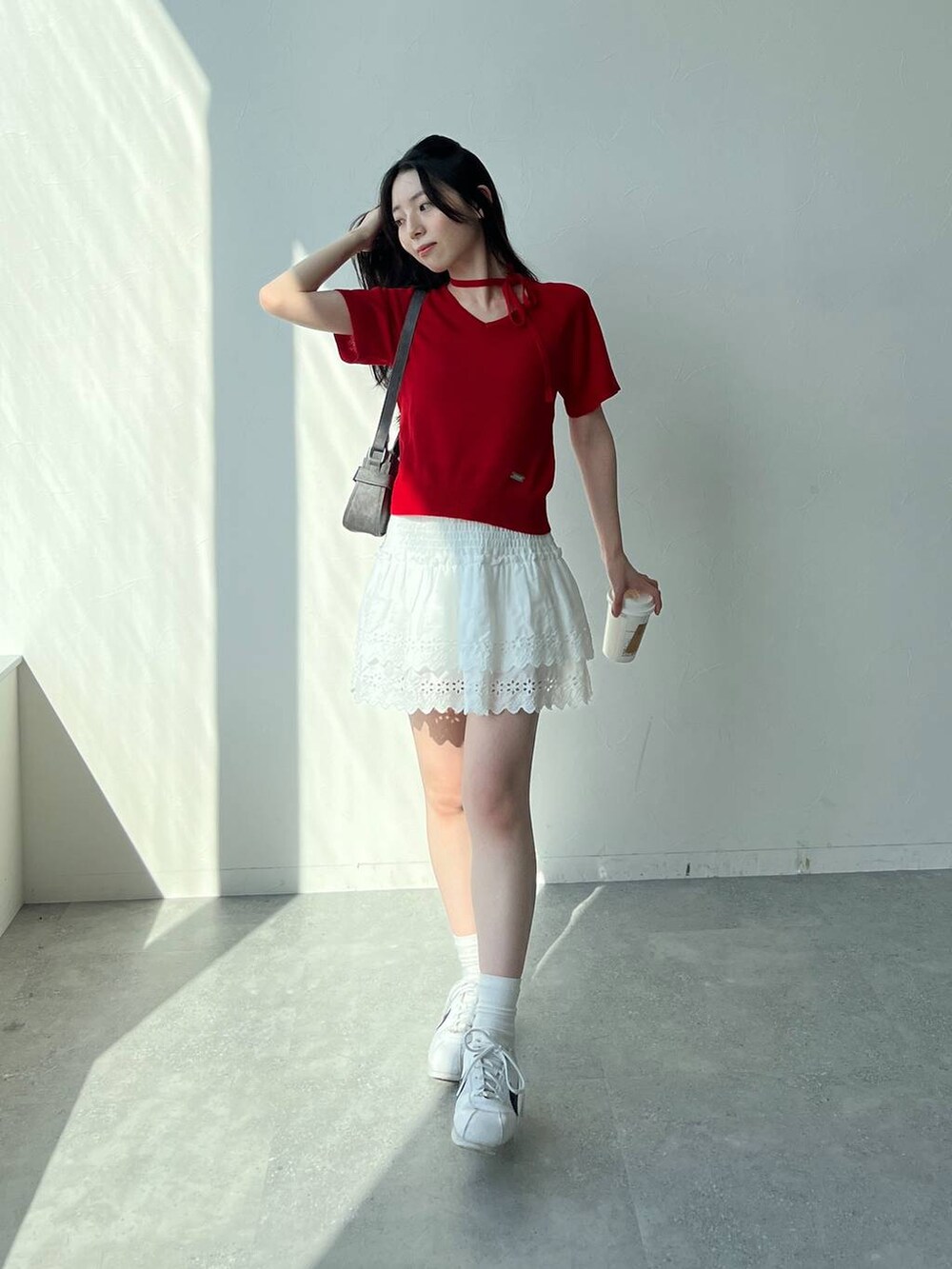 ホワイト系のスカート、ブラック系のトートバッグ、レッド系のニット/セーターを着用したレディースの夏コーディネートの7枚目の写真