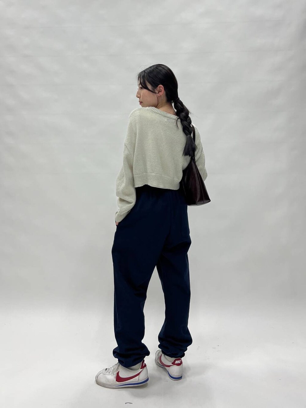 グリーン系のニット/セーターを着用したレディースの春コーディネートの3枚目の写真