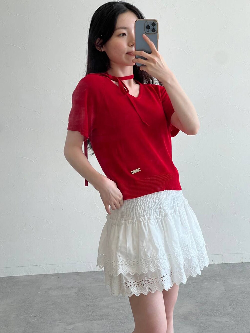 ホワイト系のスカート、ブラック系のトートバッグ、レッド系のニット/セーターを着用したレディースの夏コーディネートの4枚目の写真