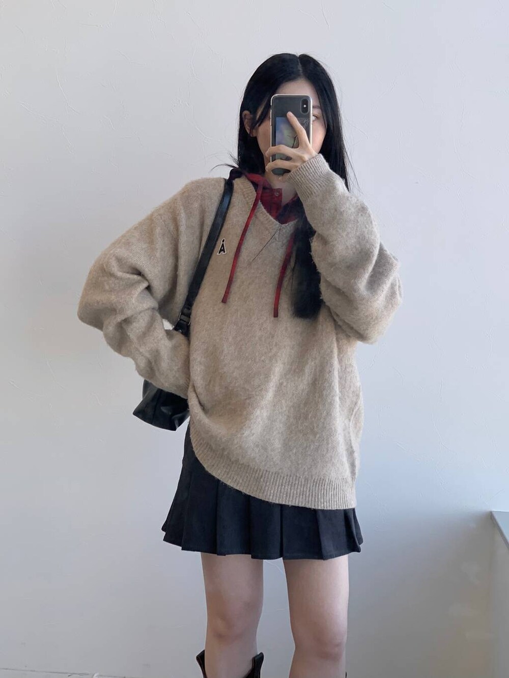 レッド系のシャツ/ブラウス、グレー系のスカート、ブラック系のハンドバッグを着用したレディースの冬コーディネートの7枚目の写真