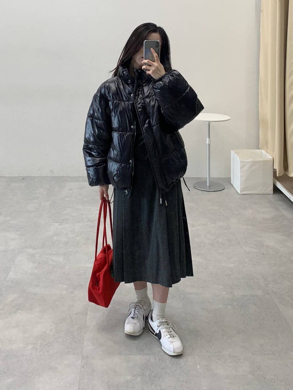 ブラック系のダウンジャケット/コート、グレー系のスカート、グレー系のTシャツ/カットソーを着用したレディースの冬コーディネートの5枚目の写真