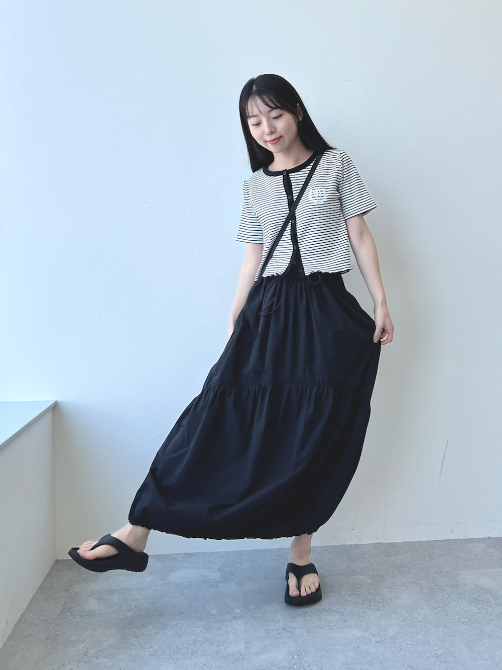 ブラック系のサンダル、ブラック系のスカート、その他のカーディガン/ボレロを着用したレディースの夏コーディネートの2枚目の写真