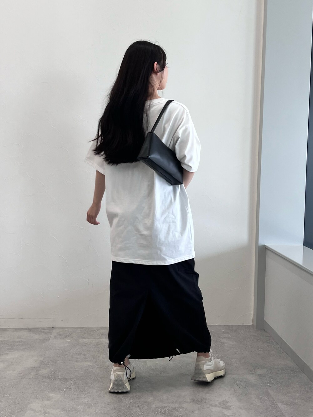 ホワイト系のTシャツ/カットソー、ブラック系のスカート、ホワイト系のスニーカーを着用したレディースの夏コーディネートの4枚目の写真