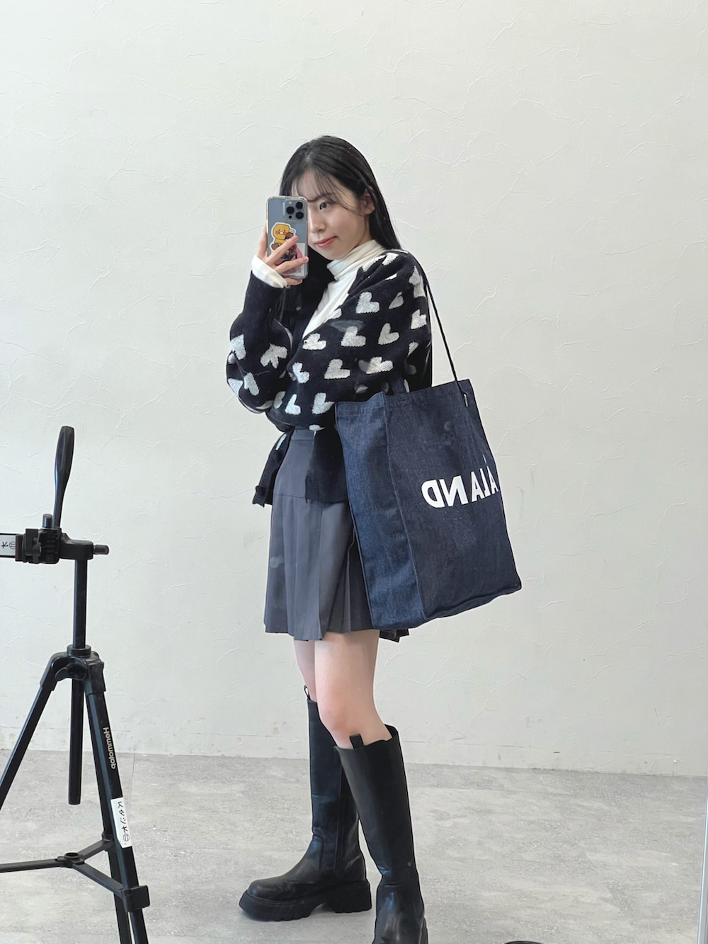 ブルー系のバッグ、ブラック系のカーディガン/ボレロ、ベージュ系のTシャツ/カットソーを着用したレディースの冬コーディネートの2枚目の写真