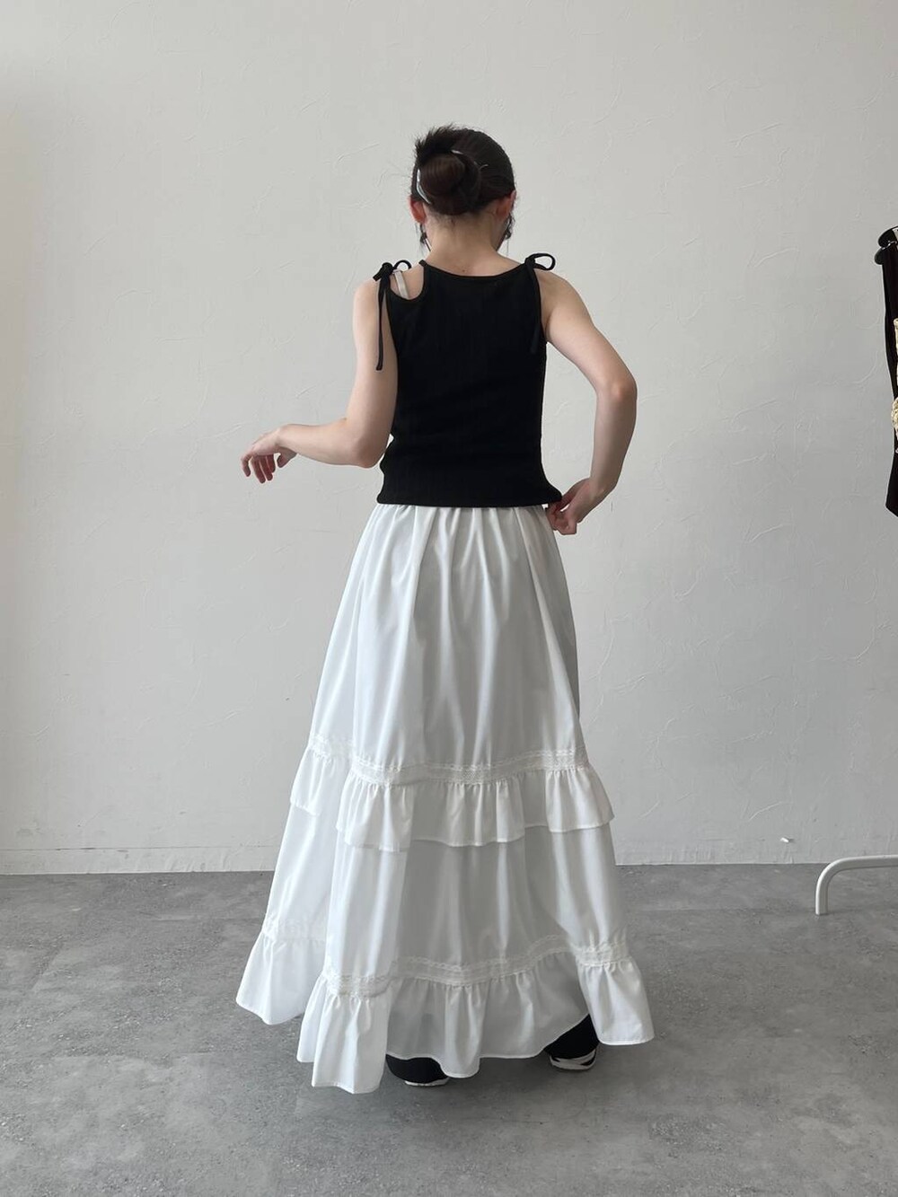 ホワイト系のスカート、ブラック系のキャミソールを着用したレディースの夏コーディネートの4枚目の写真