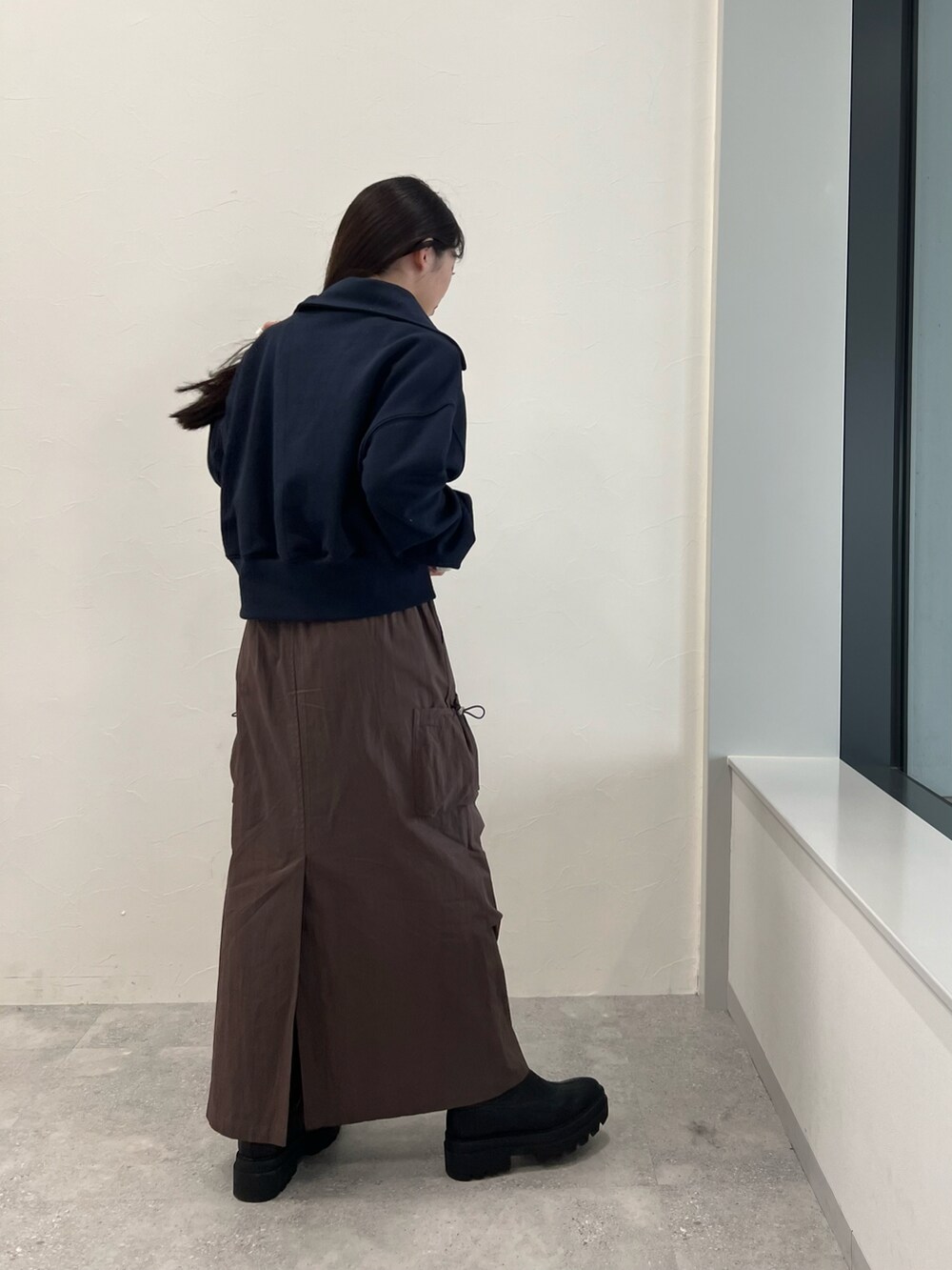 ブルー系のスウェット、ベージュ系のTシャツ/カットソー、ブラウン系のスカートを着用したレディースの冬コーディネートの3枚目の写真