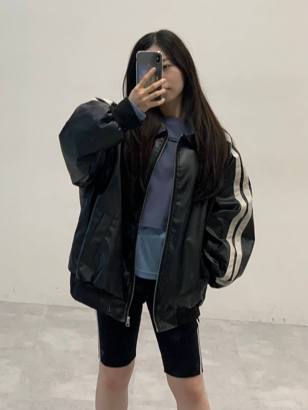 ブラック系のサンダル、ブラック系のブルゾン、ブルー系のTシャツ/カットソーを着用したレディースの秋コーディネートの6枚目の写真