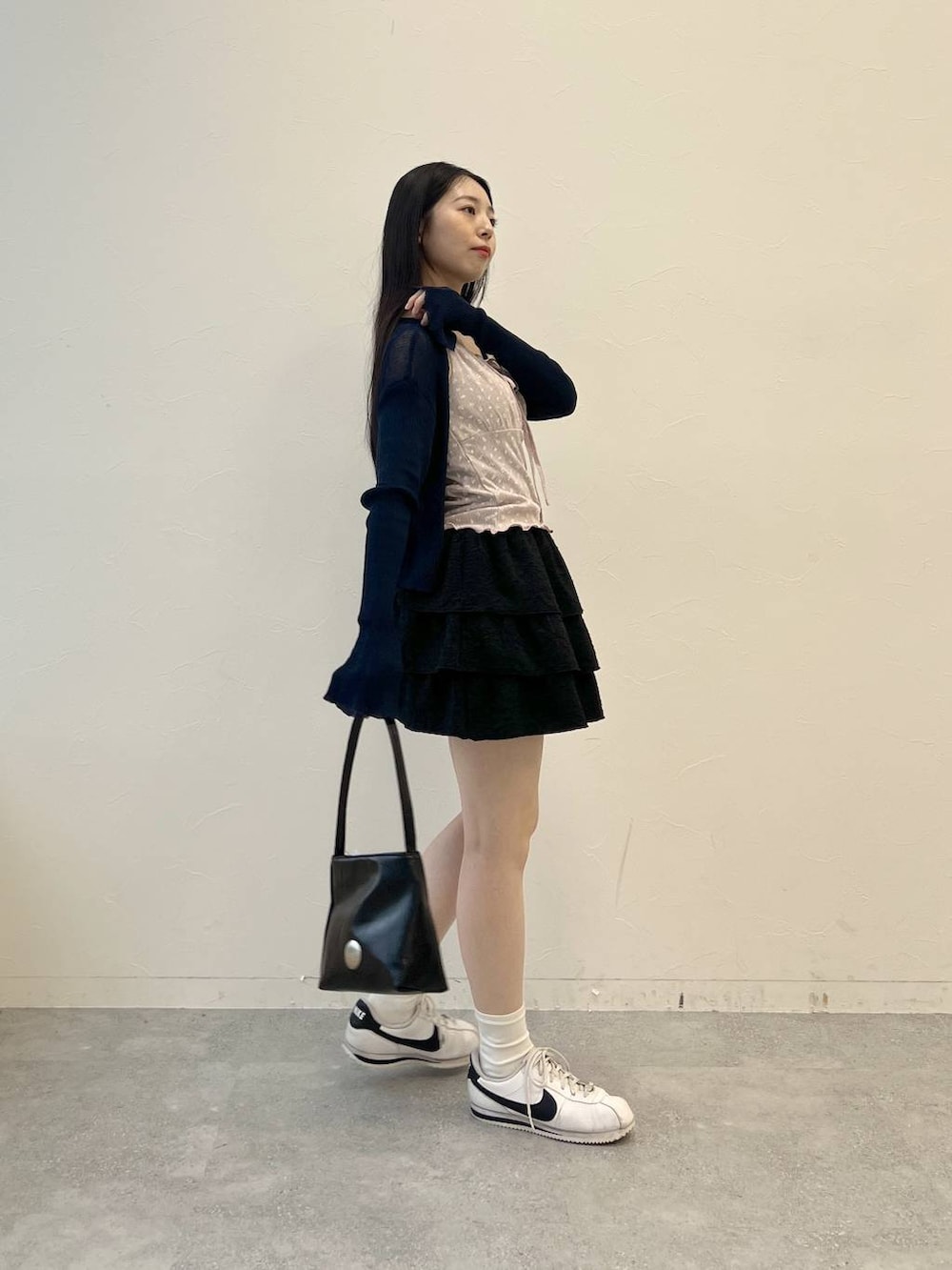 ピンク系のキャミソール、ブラック系のハンドバッグ、ブラック系のスカートを着用したレディースの夏コーディネートの5枚目の写真