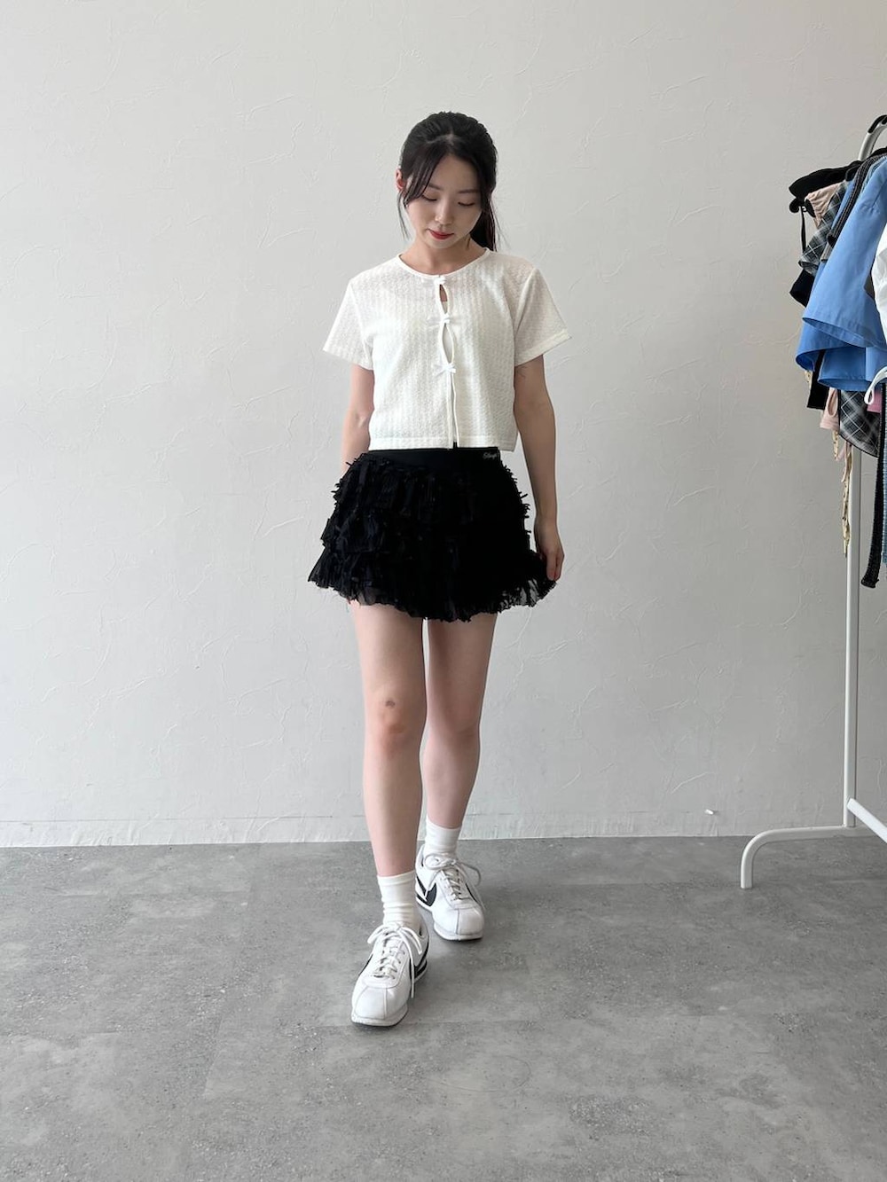 ホワイト系のTシャツ/カットソー、ブラック系のスカートを着用したレディースの夏コーディネートの2枚目の写真