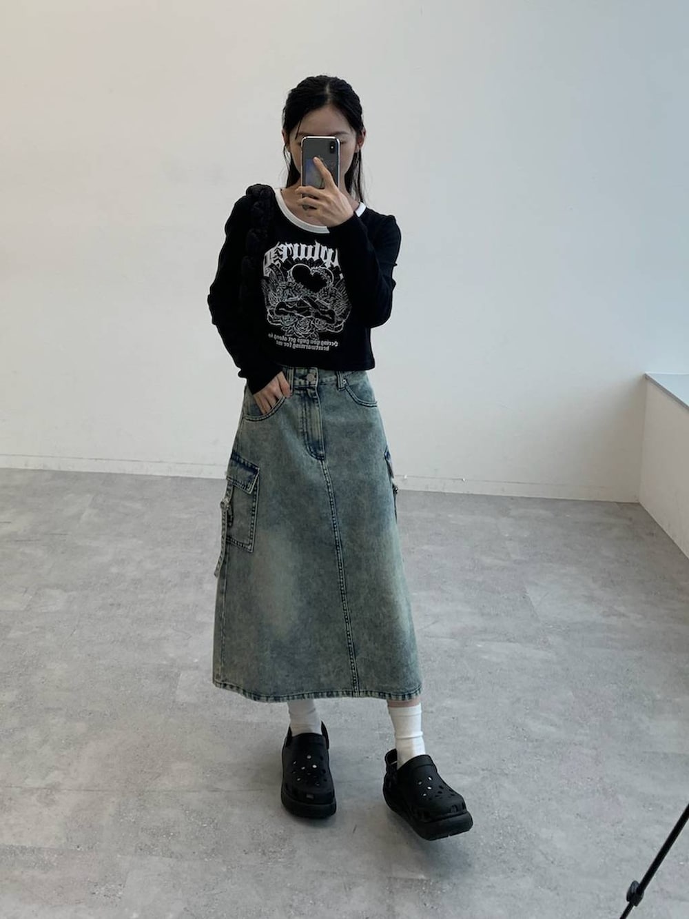 ブラック系のサンダル、ブラック系のショルダーバッグ、ブルー系のデニムスカートを着用したレディースの秋コーディネートの2枚目の写真