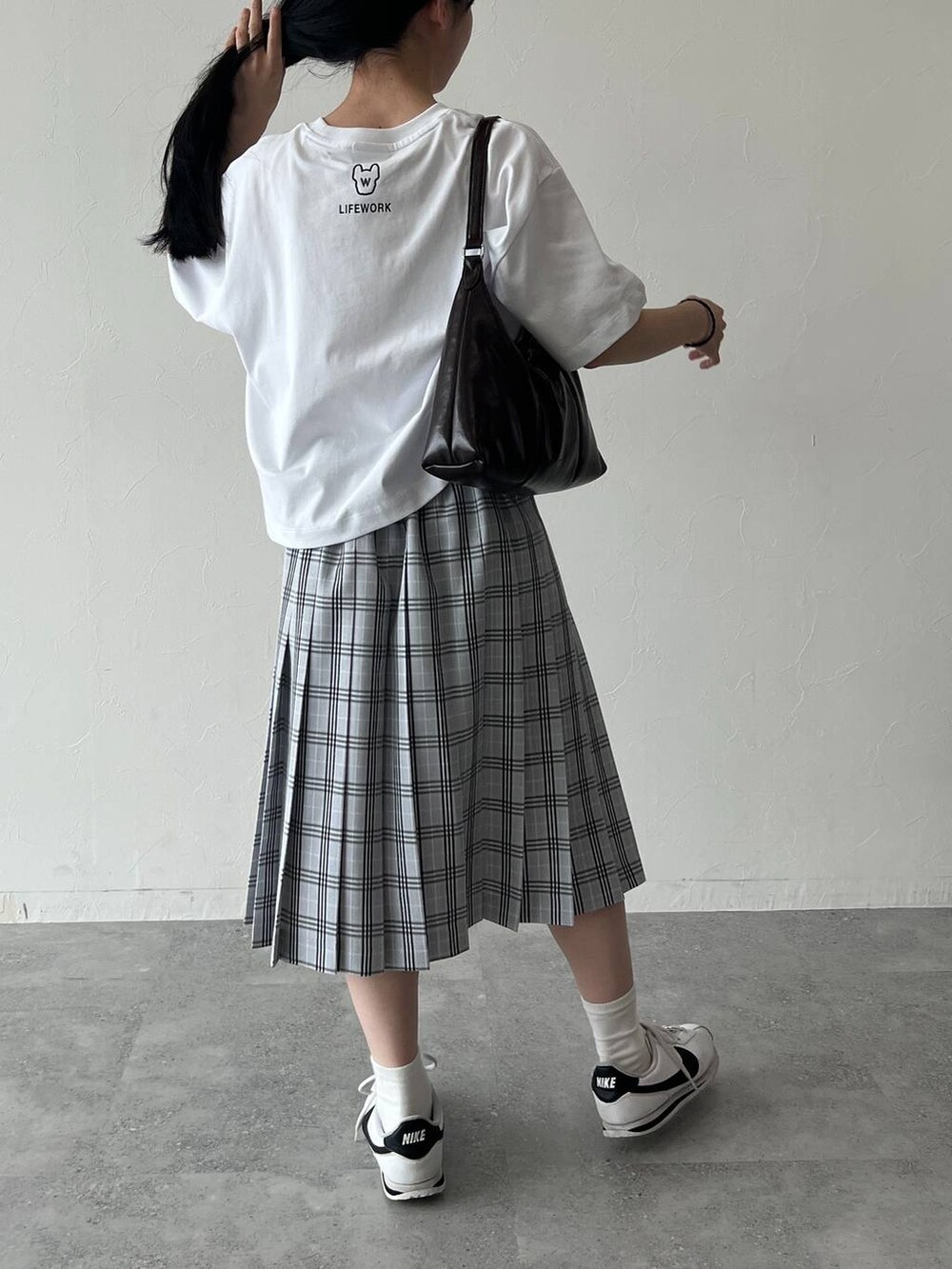 ブルー系のスカート、ホワイト系のTシャツ/カットソーを着用したレディースの夏コーディネートの3枚目の写真